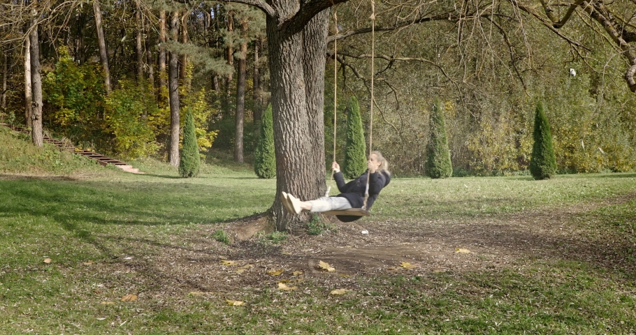 Little Girl Swinging On Tree Swing.