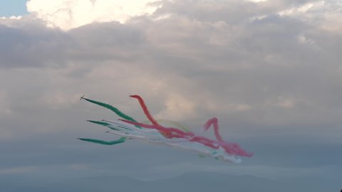 Rivolto Italy SEPTEMBER, 17, 2021 Group of military jets fly synchronized rolls spraying the italian flag red green contrails smoke in the sky on airshow. Aermacchi MB-339 of Frecce Tricolori. 