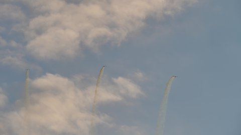 Rivolto Italy SEPTEMBER, 17, 2021 Tracking view three jets perform synchronised loop in sky with scenic sky background and white smoke trails. Aermacchi MB-339 of Frecce Tricolori. 