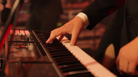 Male hands playing on piano electronic keyboard. The musician playing the electric piano, Electric piano. Actor playing on the keyboard synthesizer piano keys