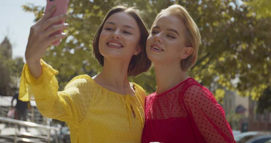 Beautiful young women taking selfie outdoors