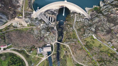 Aerial view drone shot above water dam. Top down shot over a water reservoir with Asphalt road bridge above hydroelectric renewable power plant. High quality 4k footage