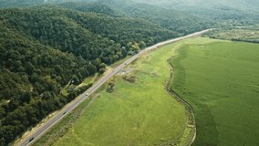 Vehicles driving through rural farmland landscape in Virginia, USA. 4K aerial drone footage. Transportation concept.