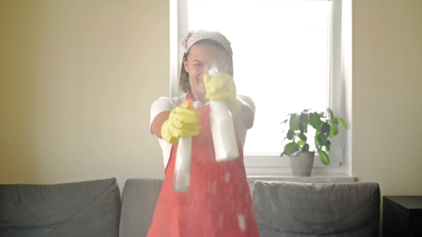 Tired of boring work, the housewife started a fun game with the Hand Sprayers. | Shutterstock HD Video #1080575975