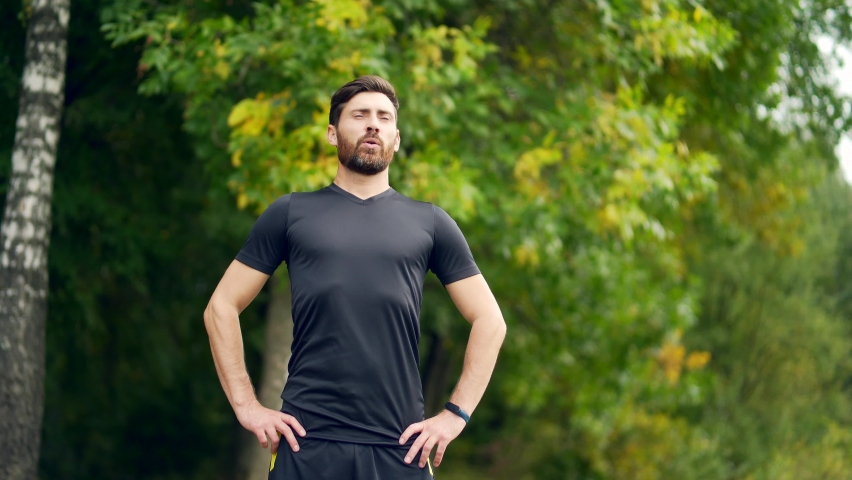 Close up portrait young happy bearded man standing in nature between forest trees relaxes, breathes fresh air closing his eyes. Male enjoys a life of peace calm, quiet in the park. Outdoors. Happiness Royalty-Free Stock Footage #1080576623