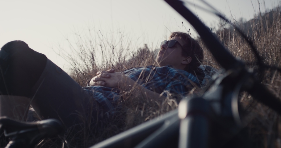 Mountain biker man rests after MTB action in close up lens flares