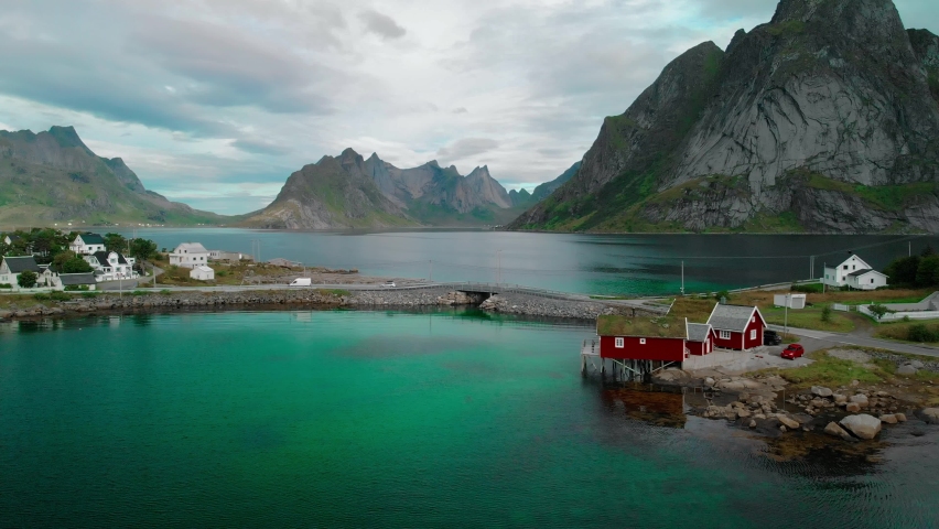 Bridge and stone dam connecting parts of small town against fjords and mountains aerial view Reine, Moskenes island, Lofoten islands, Norway