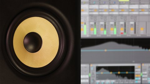 Yellow studio monitor speaker on the background of music software, with equalizers and volume indicators