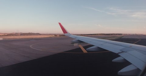 Taxiing on runway shot from inside of plane during sunset in Madrid Barajas Adolso Suarez Airport
