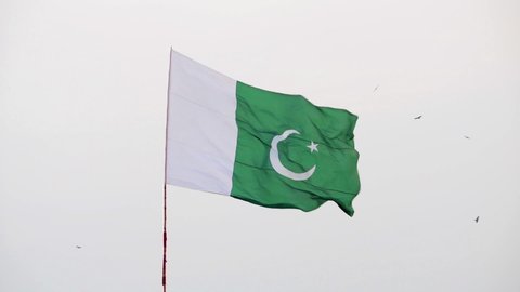 Huge Pakistani flag Up in the air waving on a pole. Pakistani flag waving on a windy day.