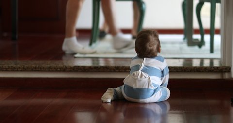 Baby infant on hardwood floor at home crawling and reaching to electrical outlet
