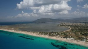 Aerial drone video of famous for water sports like kitesurfing sandy turquoise beach of Agios Ioannis with old abandoned windmills and lovely clouds, Lefkada island, Ionian, Greece