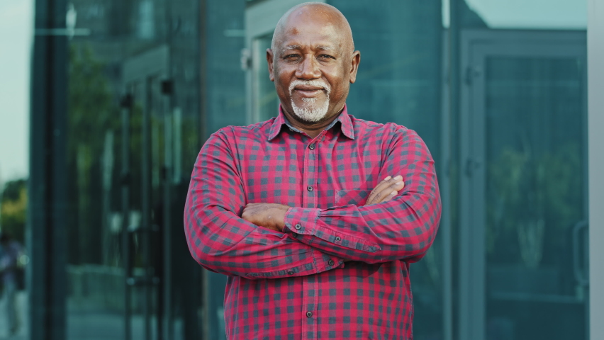 Portrait Elderly African American man with gray beard standing outdoor with arms crossed on chest, nonverbal communication concept, closeup adult person of retirement age showing gesture confidence | Shutterstock HD Video #1080599486