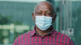 Closeup front view concerned human face portrait person wear facial mask, retired mature man pose outdoors look at camera feels afraid. COVID-19 epidemic pandemic virus outbreak protection concept - Powered by Shutterstock - Get 15% off with code: PIKWIZARD15
