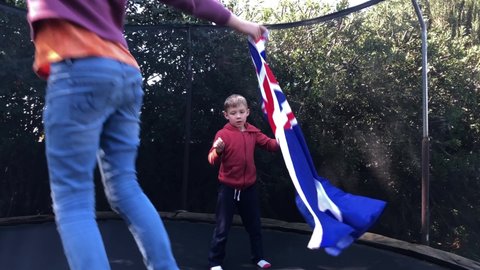 Kids jumping with Australia flag on trampoline.