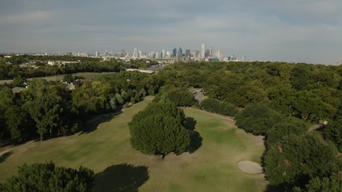 Aerial view of golf course park landscape with Dallas, Texas skyline in Oak Cliff neighborhood - 4K Drone