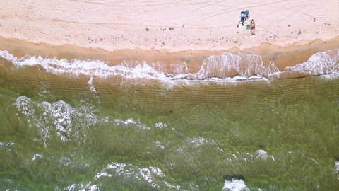 Slow motion overhead drone clip over a beatiful beach with crystal waters and waves crushing on the ground in Keramoti, Kavala,Northern Greece