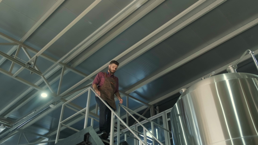 Young male brewer works at a modern brewery