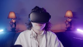 Cute young lady with curly hair playing game with vr technology she smiling on neon light background