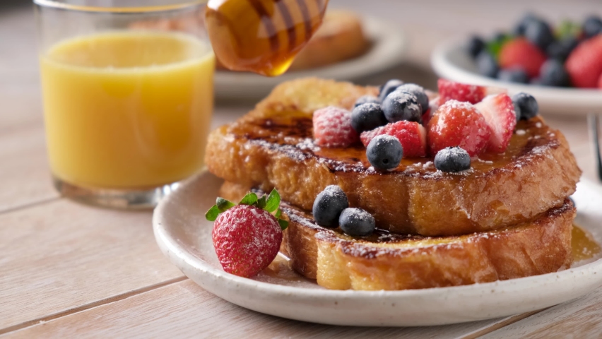 Pouring honey on french toast with berries. Sweet breakfast food | Shutterstock HD Video #1080635498