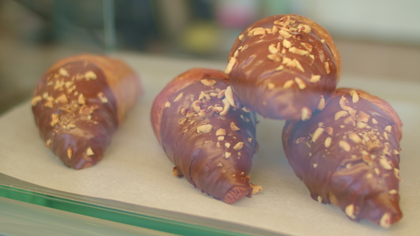many different sweet pastries on the showcase of the cafe. many different croissants with different fillings behind the glass.