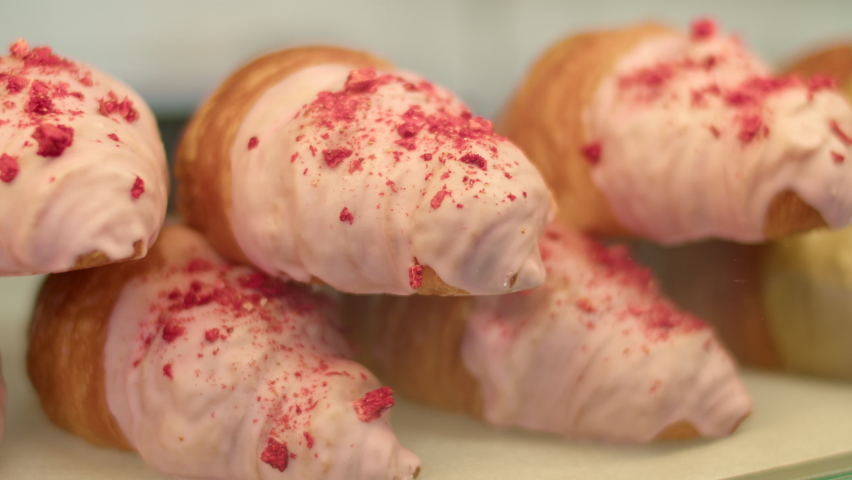 many different sweet pastries on the showcase of the cafe. many different croissants with different fillings behind the glass.