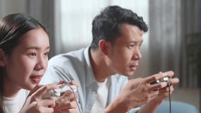 Young Asian Couple With Joystick Play Video Game On Tv And Lost

