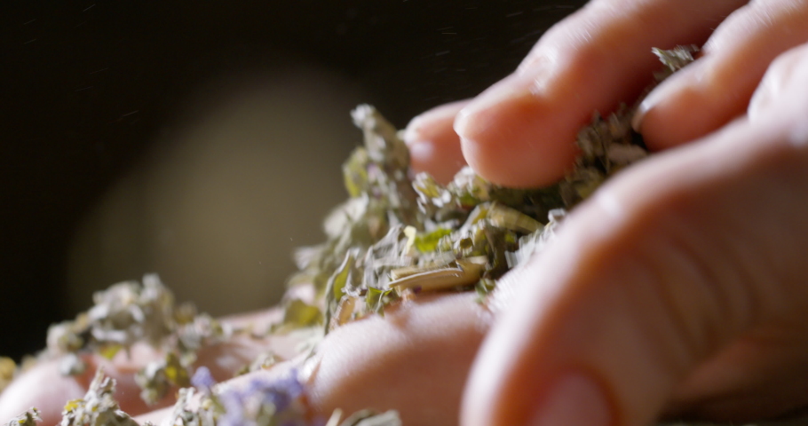 Close up shot of hands touching and rubbing dried herbs. Aromatic dry leaves and flowers for medical purposes or for tea 4k footage Royalty-Free Stock Footage #1080641756