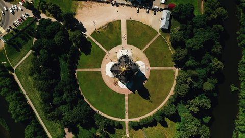 A cool beautiful temple was taken from the air and stands in the middle of a green area. The paths diverge in different directions