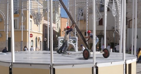Modugno, Italy - 22 september 2021: Time lapse workers mount lights in the main square to celebrate the patron saint of the city. Open air
