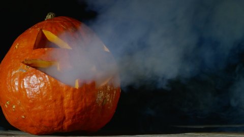 Jack O Lantern Halloween Pumpkin Blows Out Smoke Dark Background .Halloween Concept Copy Space