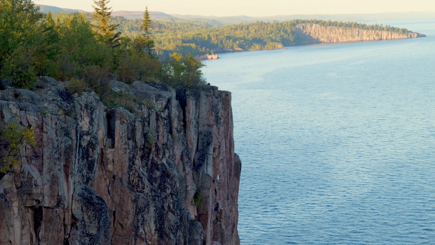Beautiful landscape along the north shore of Lake Superior in Minnesota, from Palisade Head. Unidentifiable rock climbers can also be seen high above the water on the natural sheer cliff.