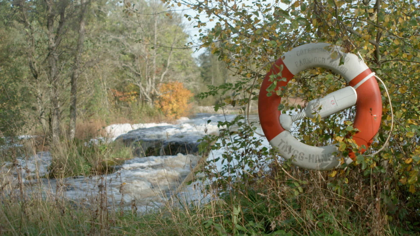 Life buoy safety wheel beside powerfull river total