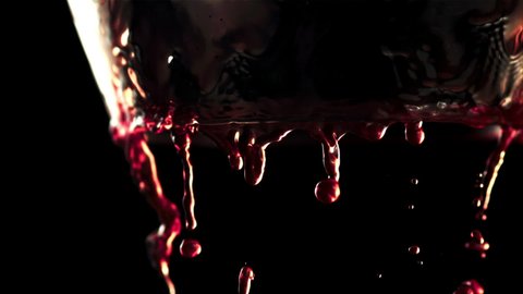 Super slow motion red wine flows down the walls of the glass. On a black background. Filmed on a high-speed camera at 1000 fps.High quality FullHD footage