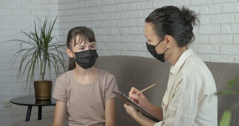 Psychologist in quarantine. A teen in mask speak about her problems with a psychologist.
