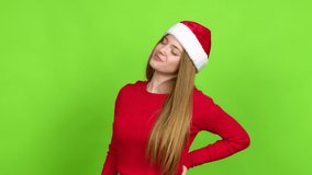 Teenager girl with christmas hat suffering from pain in shoulder for having made an effort over isolated background. Green screen chroma key
