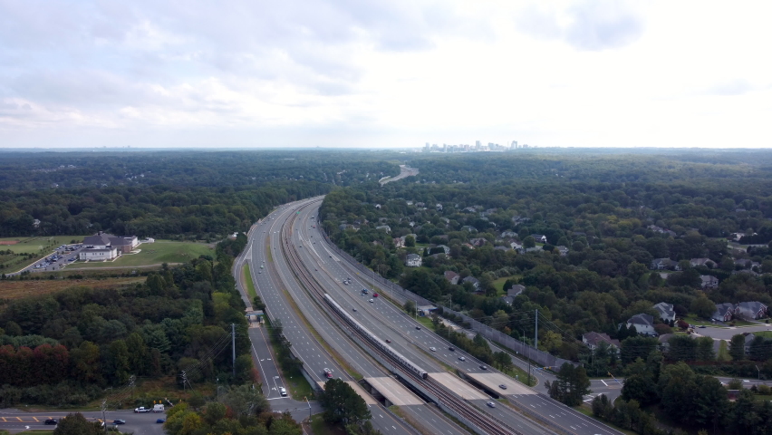 A 4k aerial video of a Silver Line Metro Train traveling down the Dulles Access Road with Tysons Corner in the distance. Royalty-Free Stock Footage #1080686279