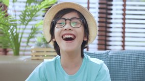 happiness asian child boy greeting hand wave to say hi  video portrait ,asian boy with glasses hand waving greeting to camera say hi or hello video calling stay home concept