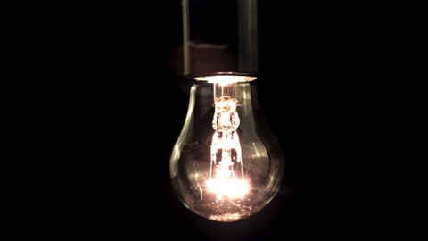 Super slow motion light bulb starts to glow. On a black background. Filmed on a high-speed camera at 1000 fps. High quality FullHD footage