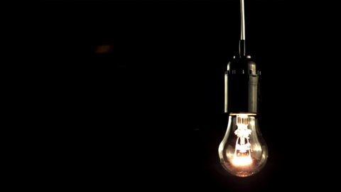Super slow motion light bulb glows. On a black background.Filmed on a high-speed camera at 1000 fps.High quality FullHD footage