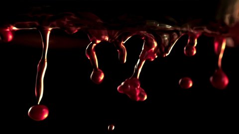 Super slow motion drops of red wine fall down. On a black background. Filmed on a high-speed camera at 1000 fps.. High quality FullHD footage