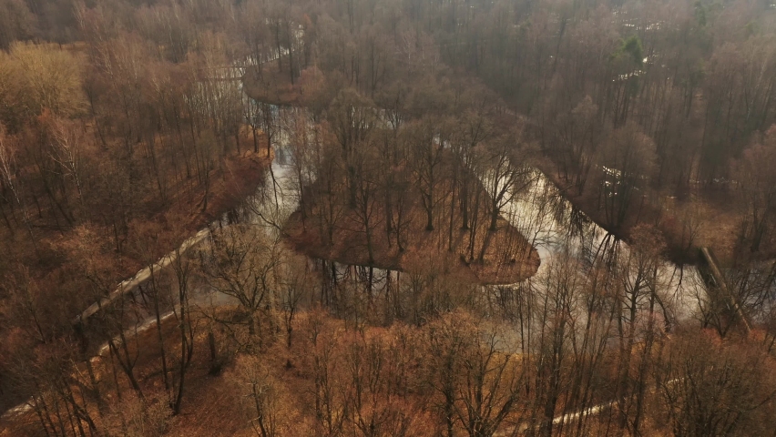 Autumn park. Aerial view. Trees without leaves. Island on river. Late in fall. Beautiful bend of iver. Forest.