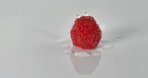 Ripe raspberry with drops of water on a white background, turns to the right, video close up with many details, 4k 24ftp