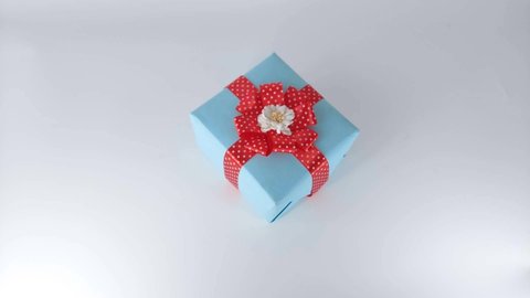 Stop motion blue gift box with red ribbon on white background