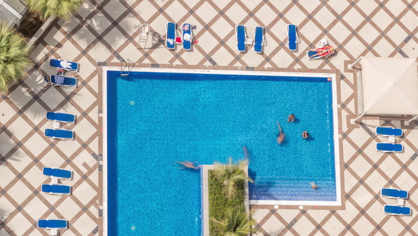 Rooftop swimming pool viewed from above timelapse, Aerial top look down view at Dubai marina. People swimming and relaxing. Dubai, UAE