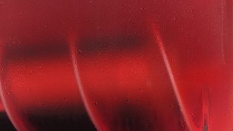 Ice strawberry fruit juice crush machine rotating inside, closeup detail, water drops on glass wall