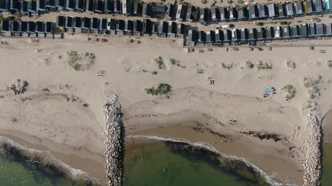 Drone shot of blue beach huts along Mudeford sandbank sandbar sunny summer seaside Dorset coast.