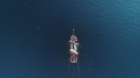 Scenic seascape view of historical European pirates ship cruising in ocean, 4K aerial travel tourism. Cinematic incredible view medieval ship sailing in blue Caribbean sea with happy people on deck