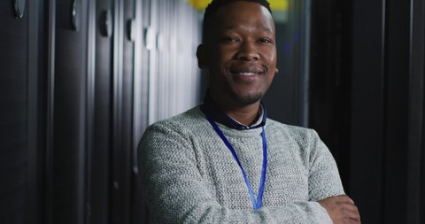 African american male computer technician with security pass in business server room. digital information storage and communication network technology.