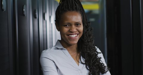 African american female computer technician with security pass in business server room. digital information storage and communication network technology.